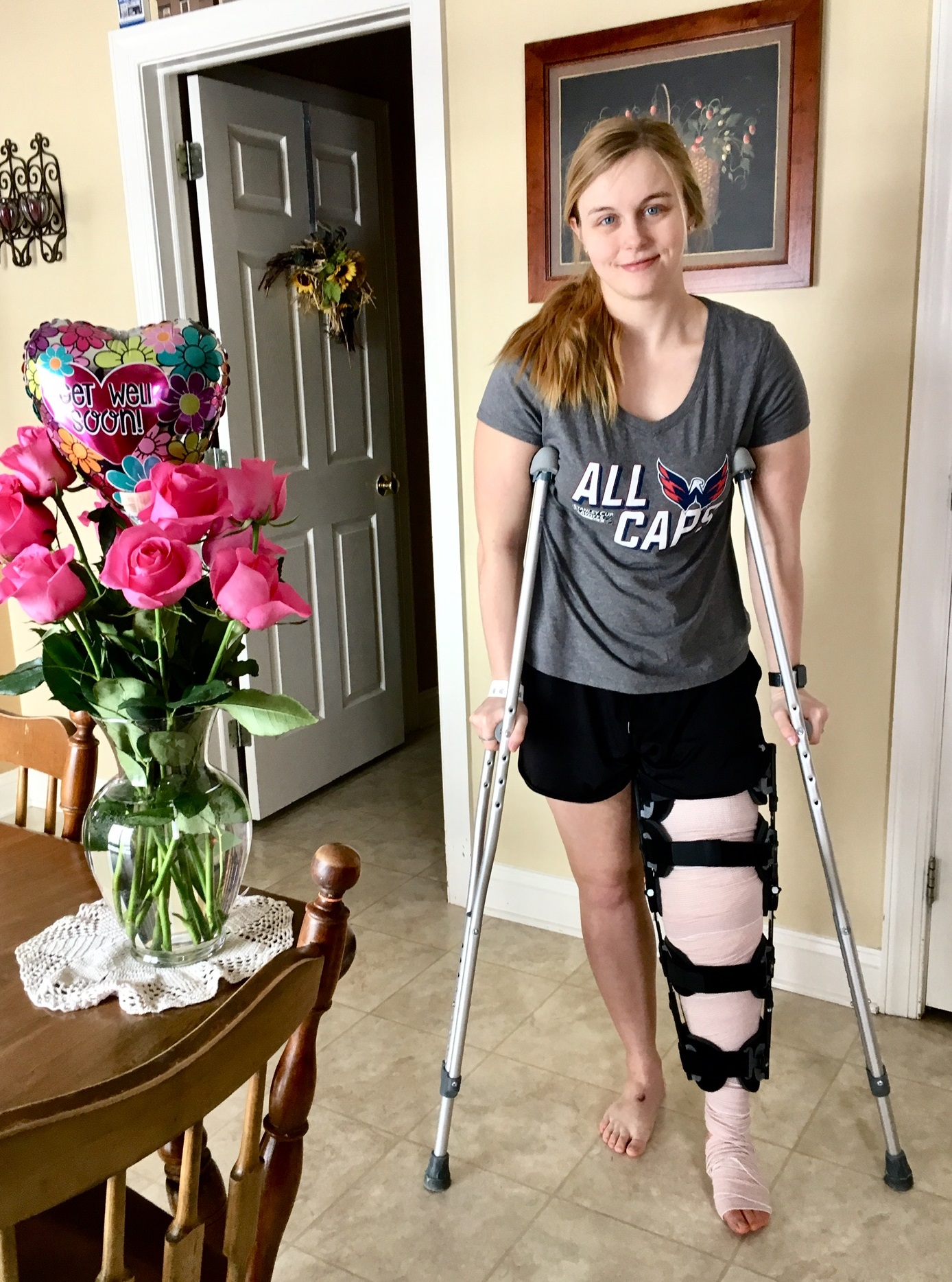 Robin wearing an ACL brace walking on crutches